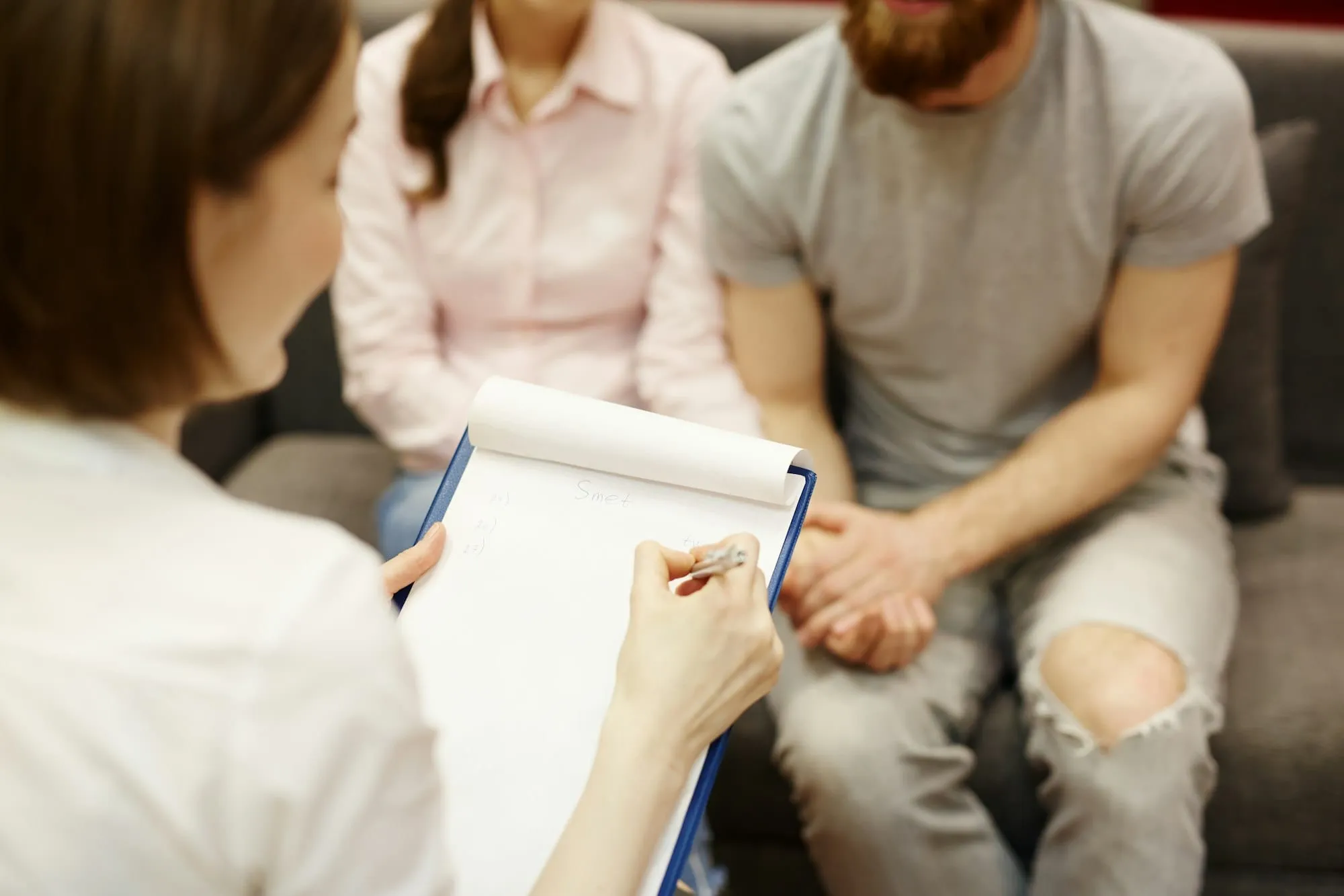 A therapist taking notes during a counseling session